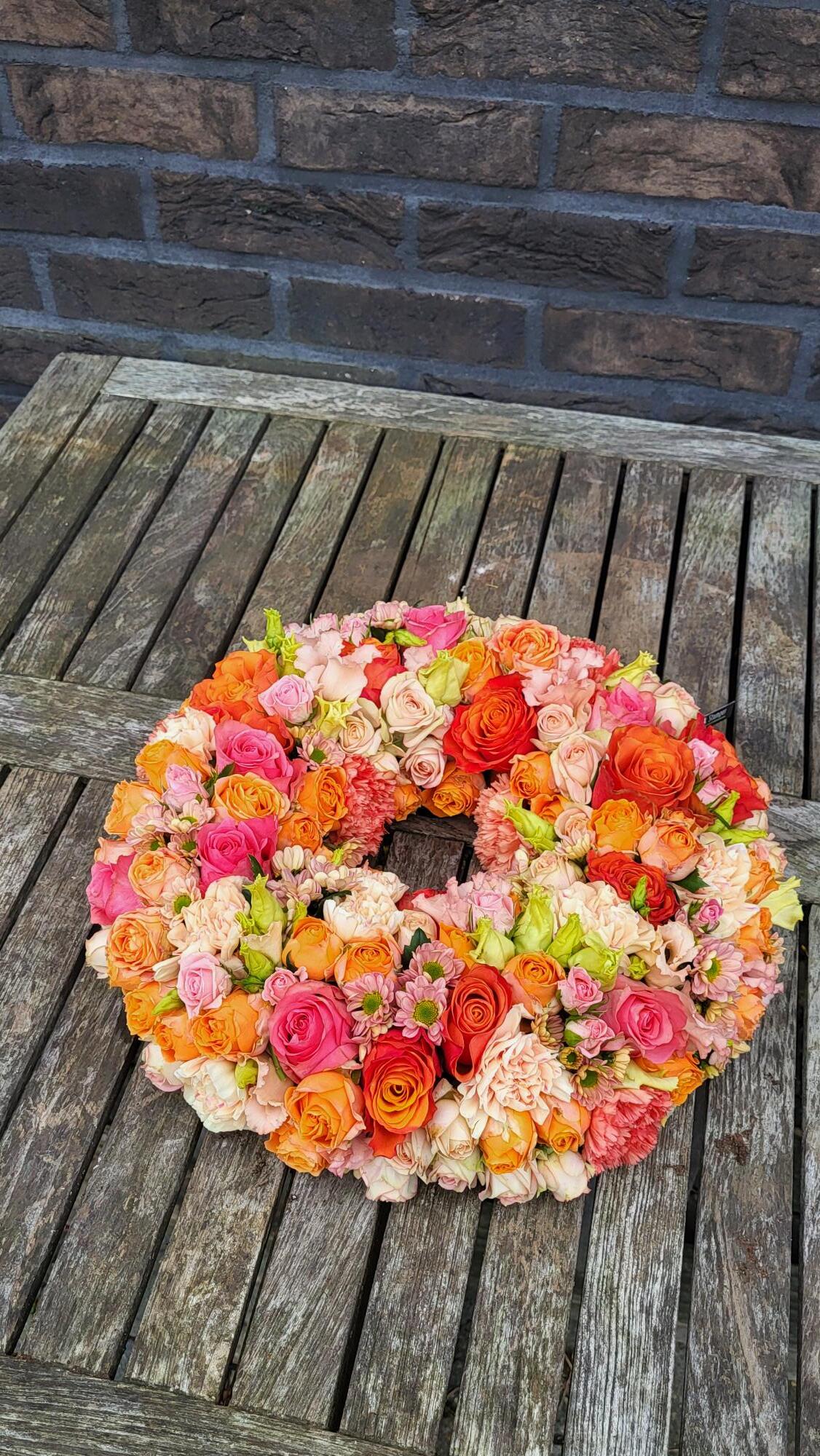 Rouwwerk 113: (Urne) krans oranje/zalm/roze tinten